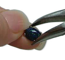 Pliers bending prongs in towards cabochon